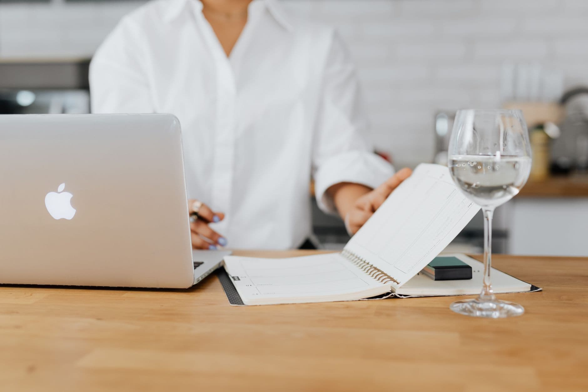 A focused freelancer working on a laptop in a well-lit home office, with a clean desk and a plant.